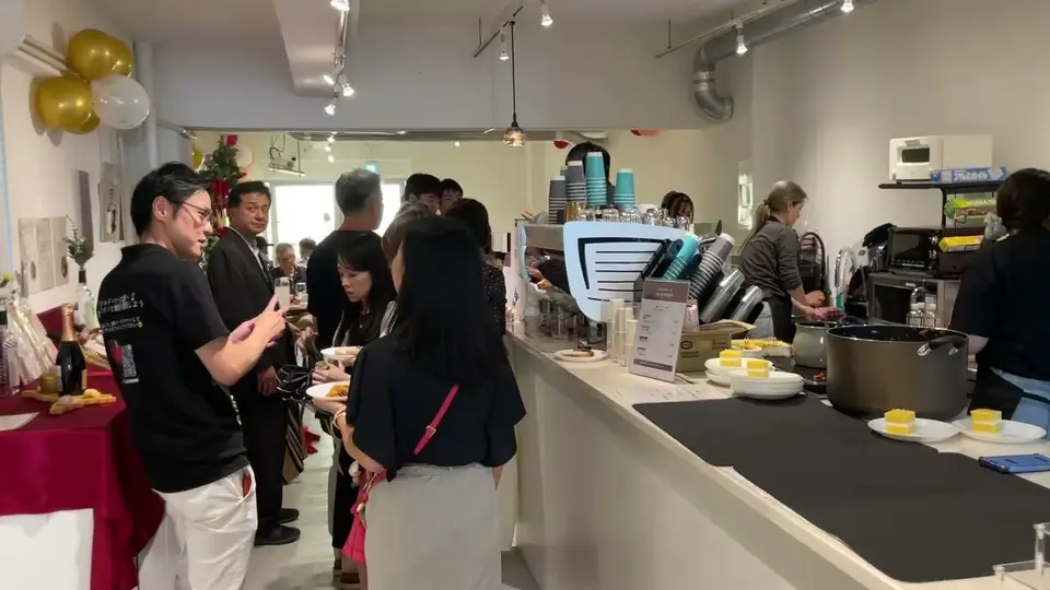 前回イベントのカウンター周辺 - ワインと料理を受け取る参加者